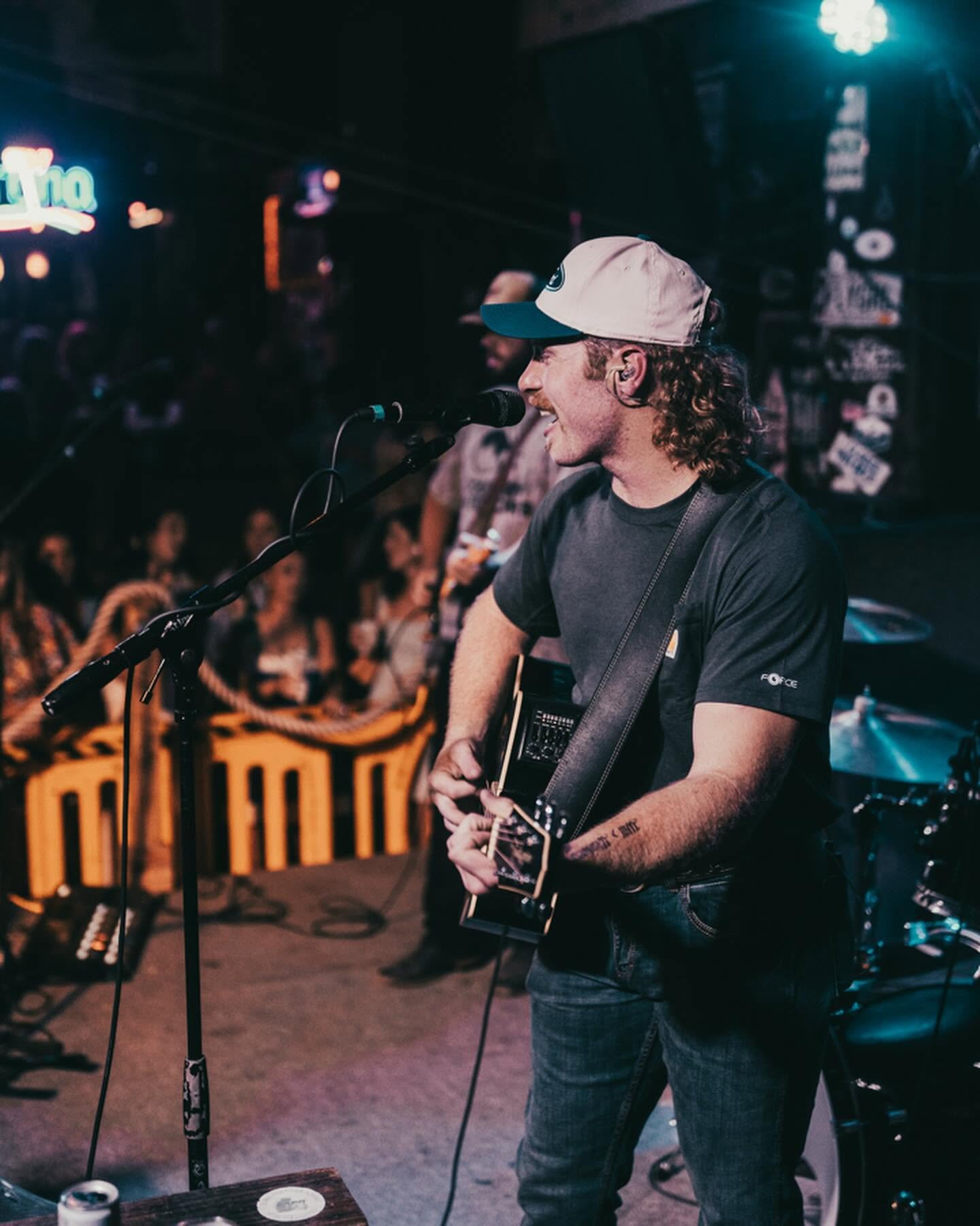 Will Shackelford singing and playing acoustic guitar under Flora-Bama stage lights